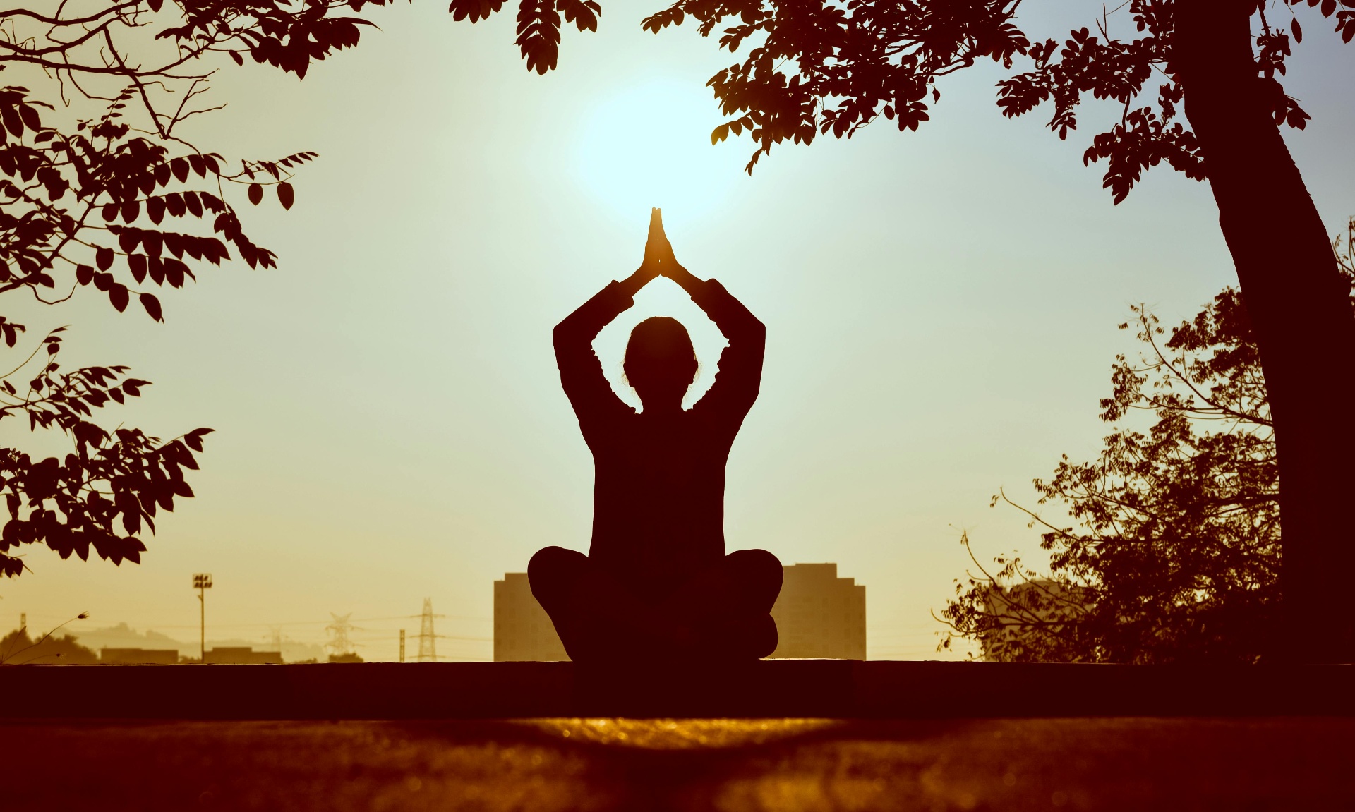 Silhouette of a person meditating at sunset